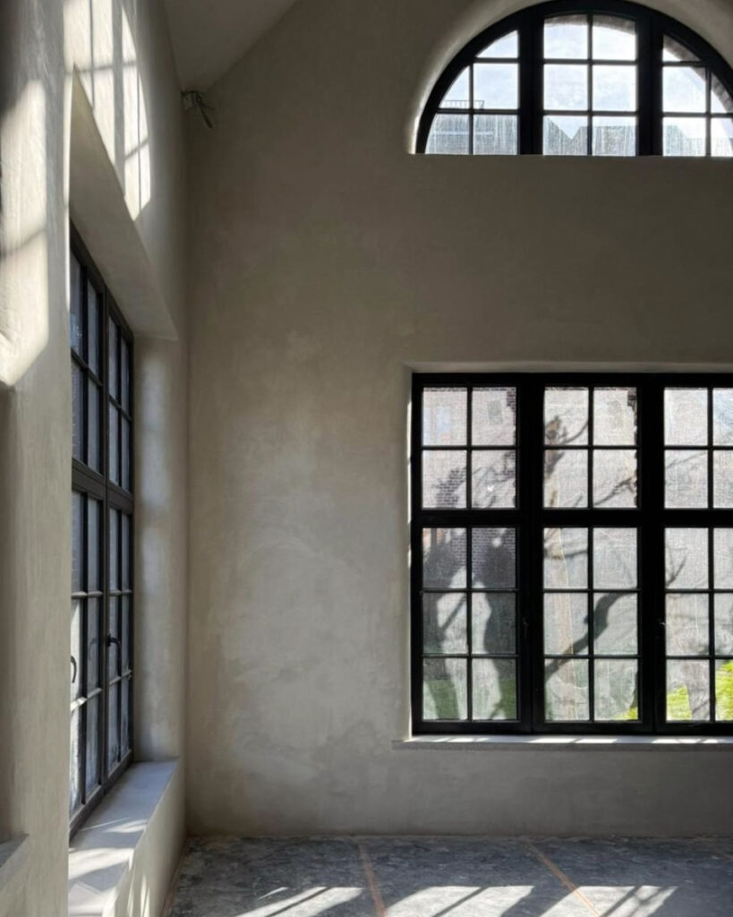 Room with large windows and a clay wall finish